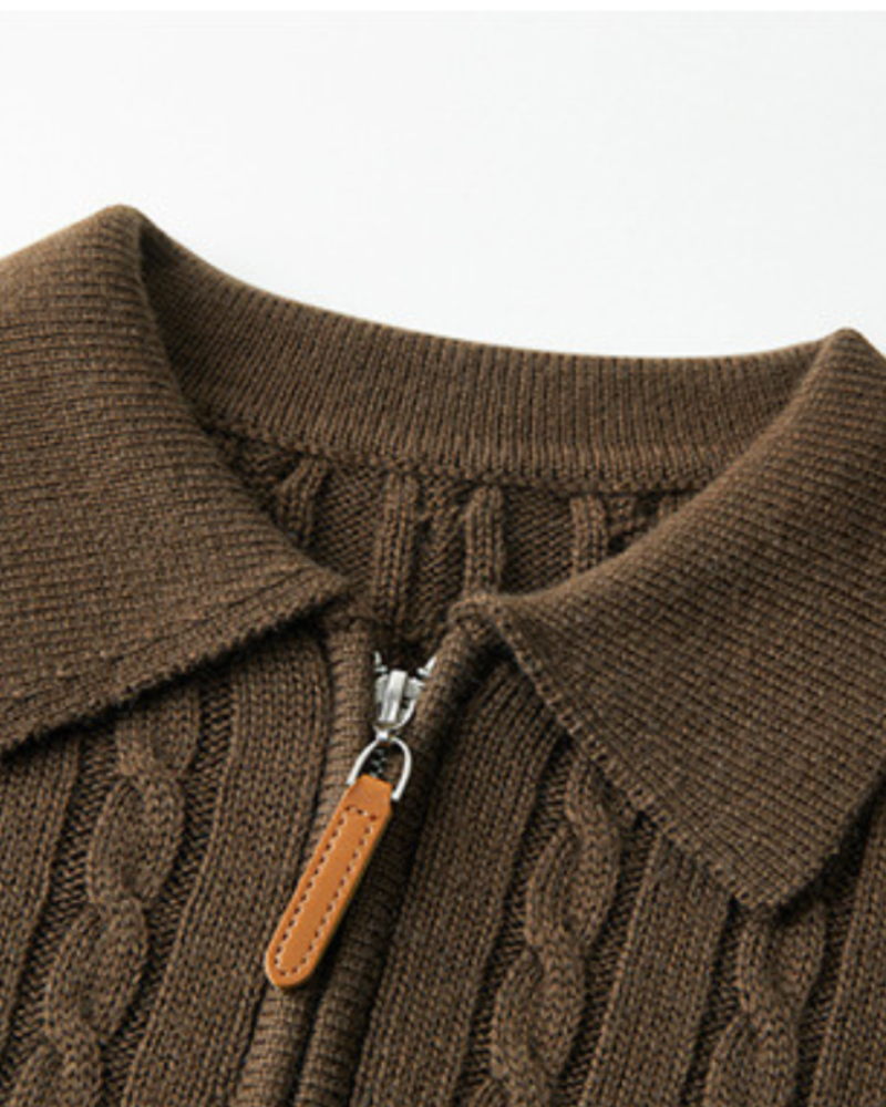 Close-up of a brown cable-knit wool polo collar with tan leather zip pull