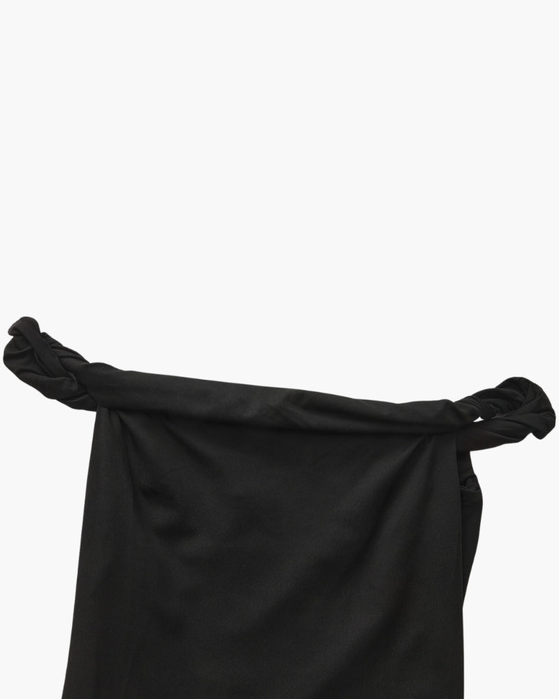 Close-up of black dress neckline with twisted braided shoulder straps