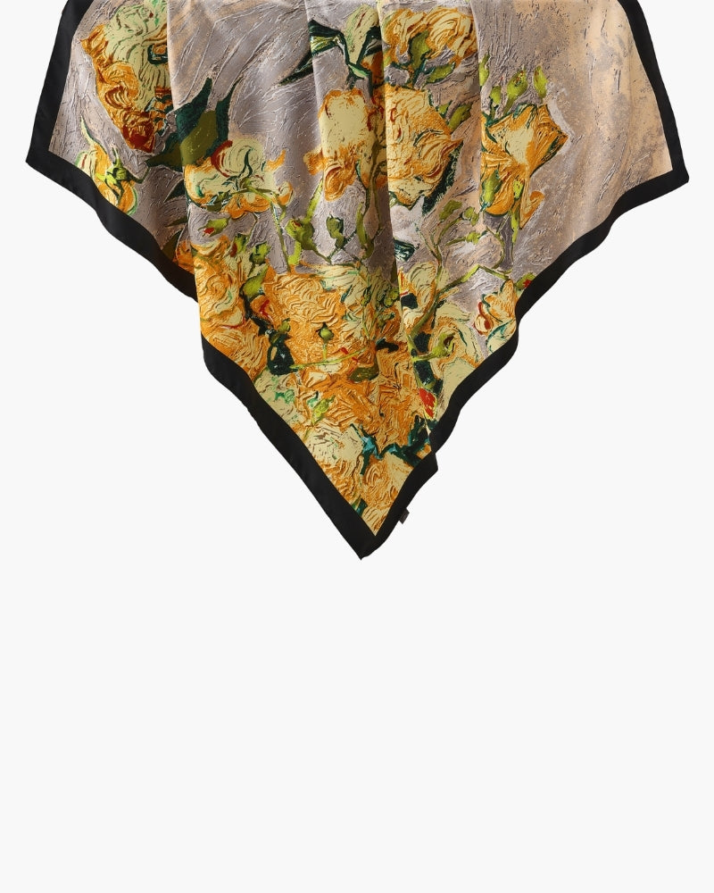 Yellow floral scarf with black border draped from a corner, flat-lay