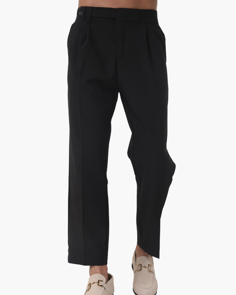 Man in black pleated trousers and cream horsebit loafers, cropped front view on white background