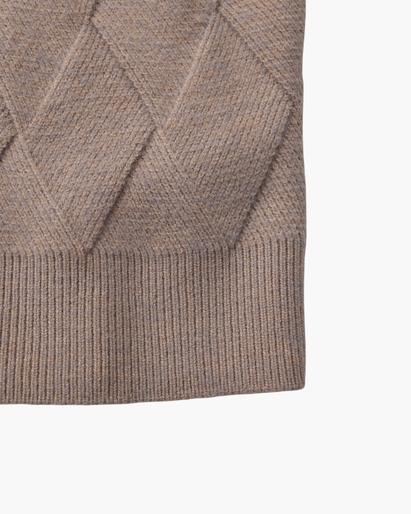 Gros plan sur le bas de manche côtelé d'un pull moka-taupe en maille losange