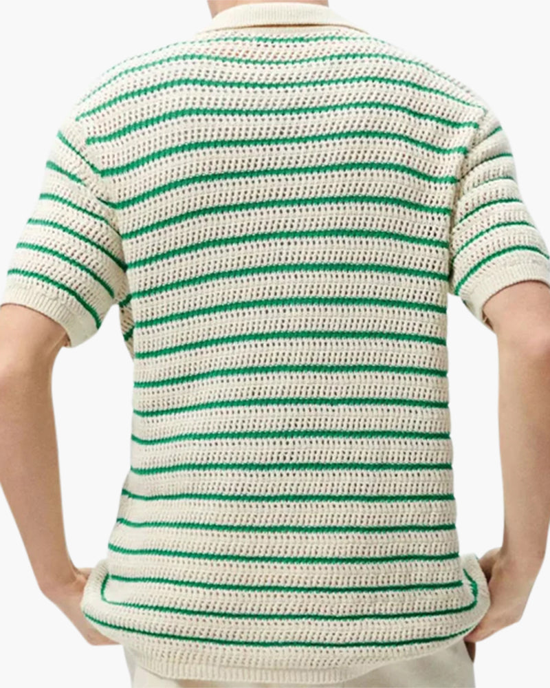 Back view of man in cream and green striped open-knit shirt, hands on hips
