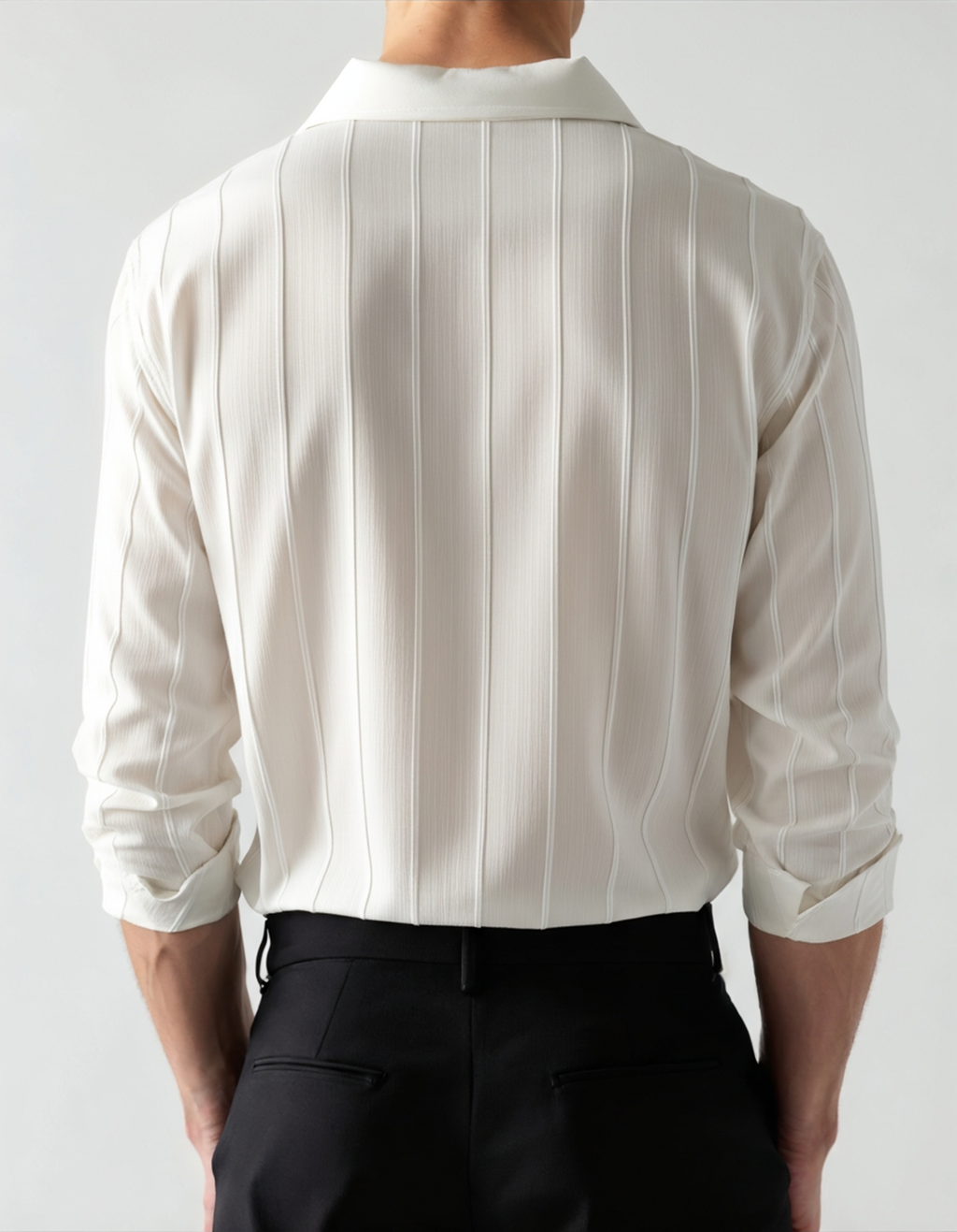 White vertical-rib shirt worn with black trousers, back view with rolled sleeves