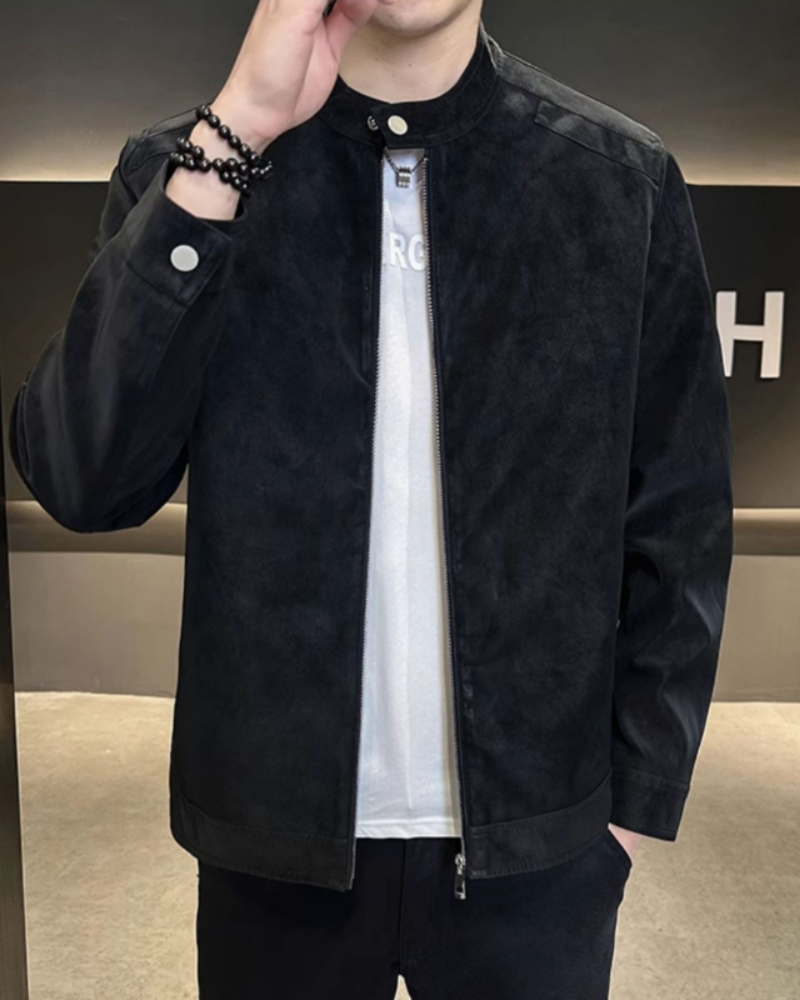 Man wearing black suede-look jacket with stand collar, hand raised, studded cuff
