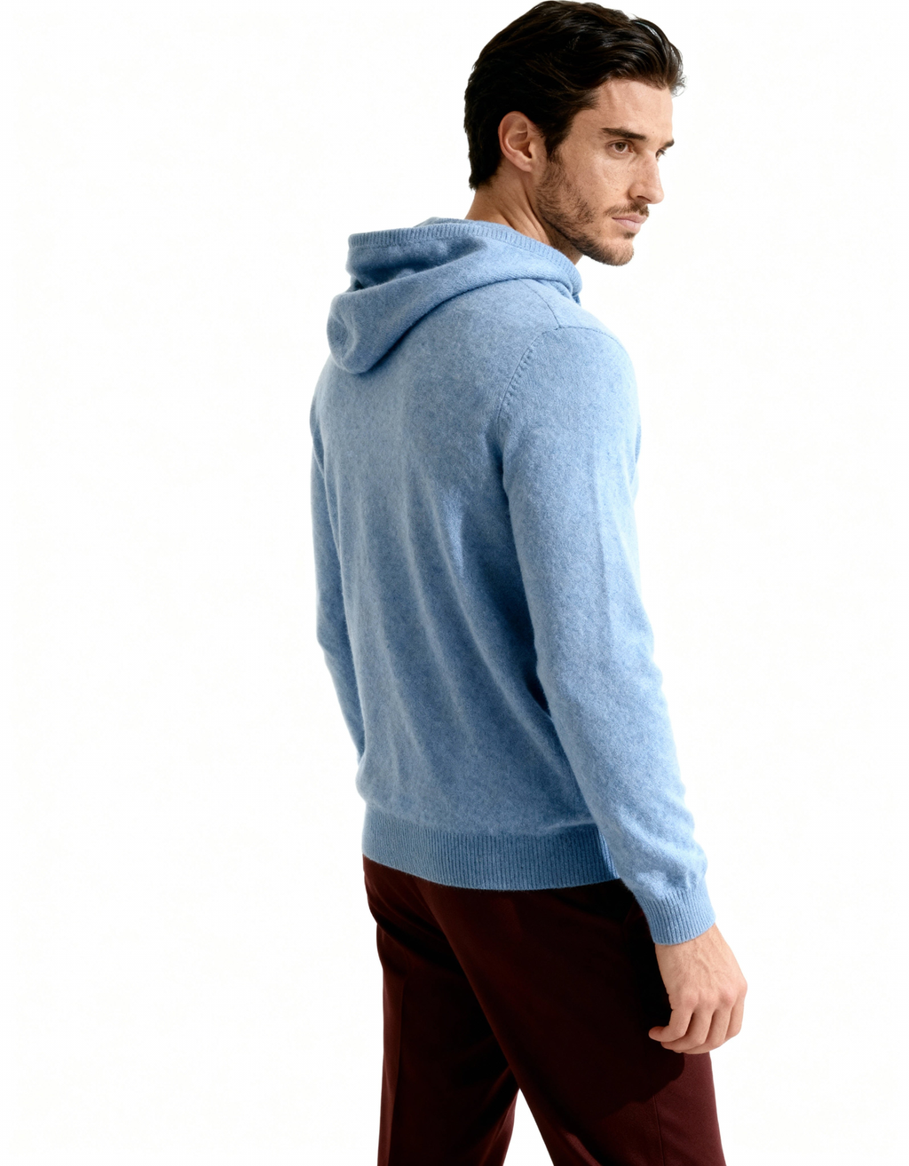 Side view of a blue cashmere hoodie showing the hood and drawstring, on model