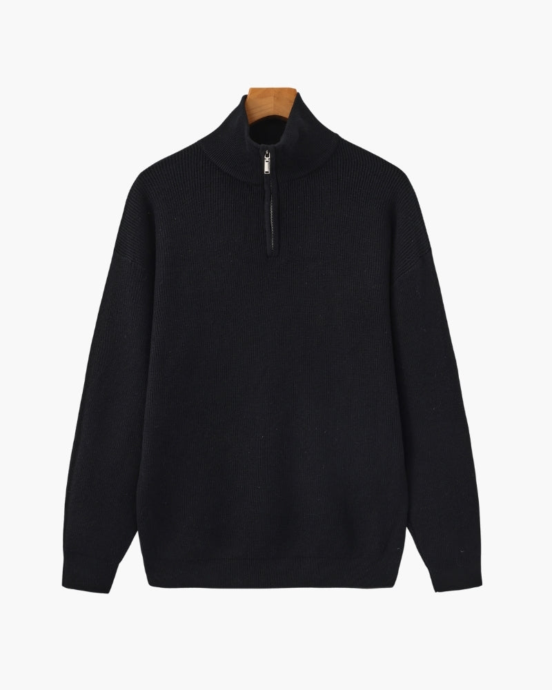 Black ribbed knit half-zip pullover with stand collar and drop shoulders, front view on a wooden hanger