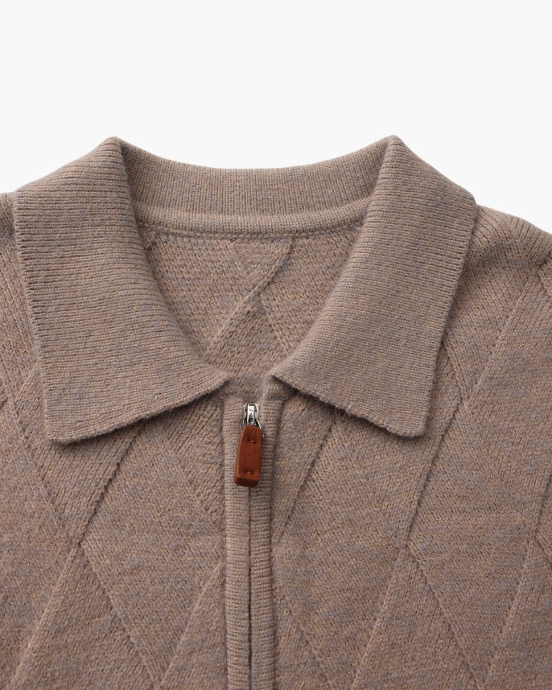 Primer plano del cuello abierto y la cremallera con tirador de piel marrón claro de una chaqueta de punto topo