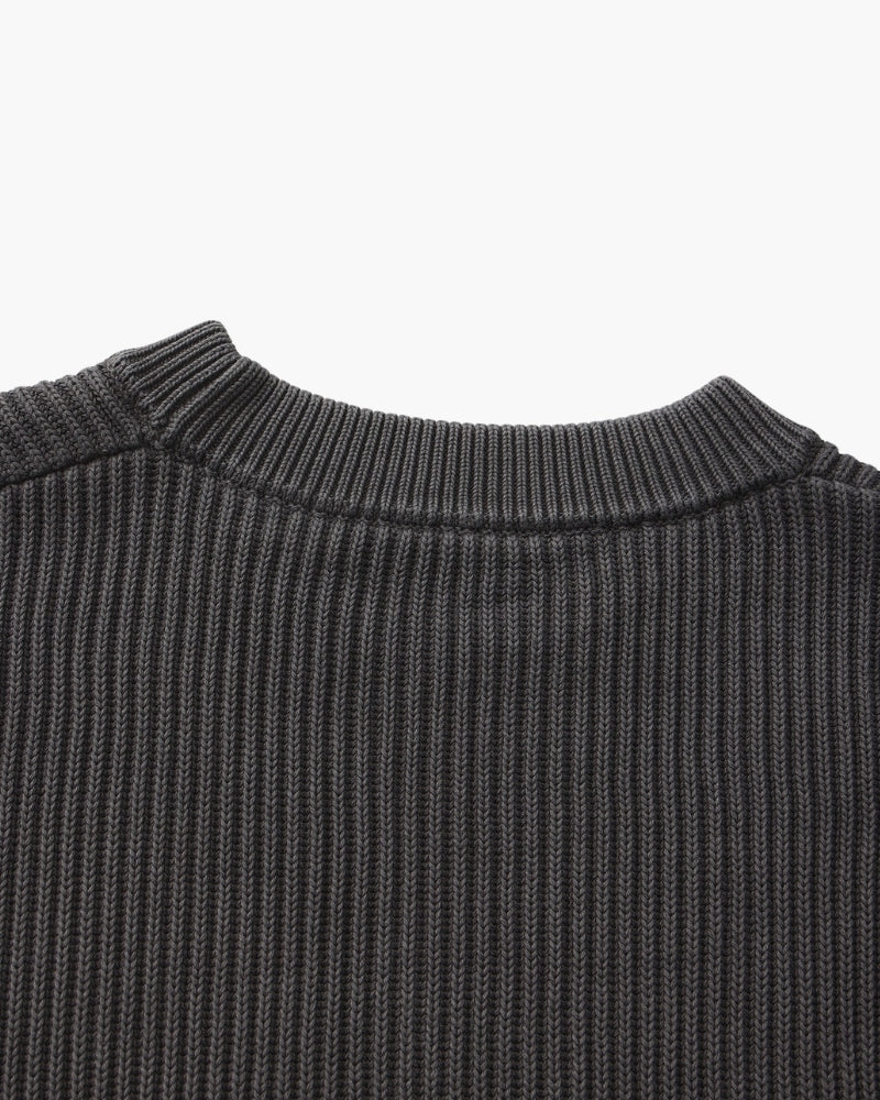 Close-up of charcoal-grey rib-knit jumper crew neckline seen from behind, flat-lay on white