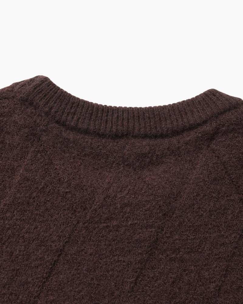 Gros plan sur le dos de l'encolure d'un pull marron foncé en maille losange