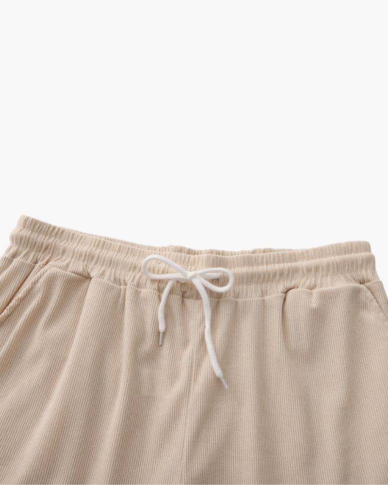 Gros plan sur un short beige à cordon, taille élastique et cordon blanc