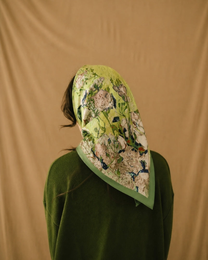 Woman from behind wearing lime green floral scarf as a headscarf, green knit top