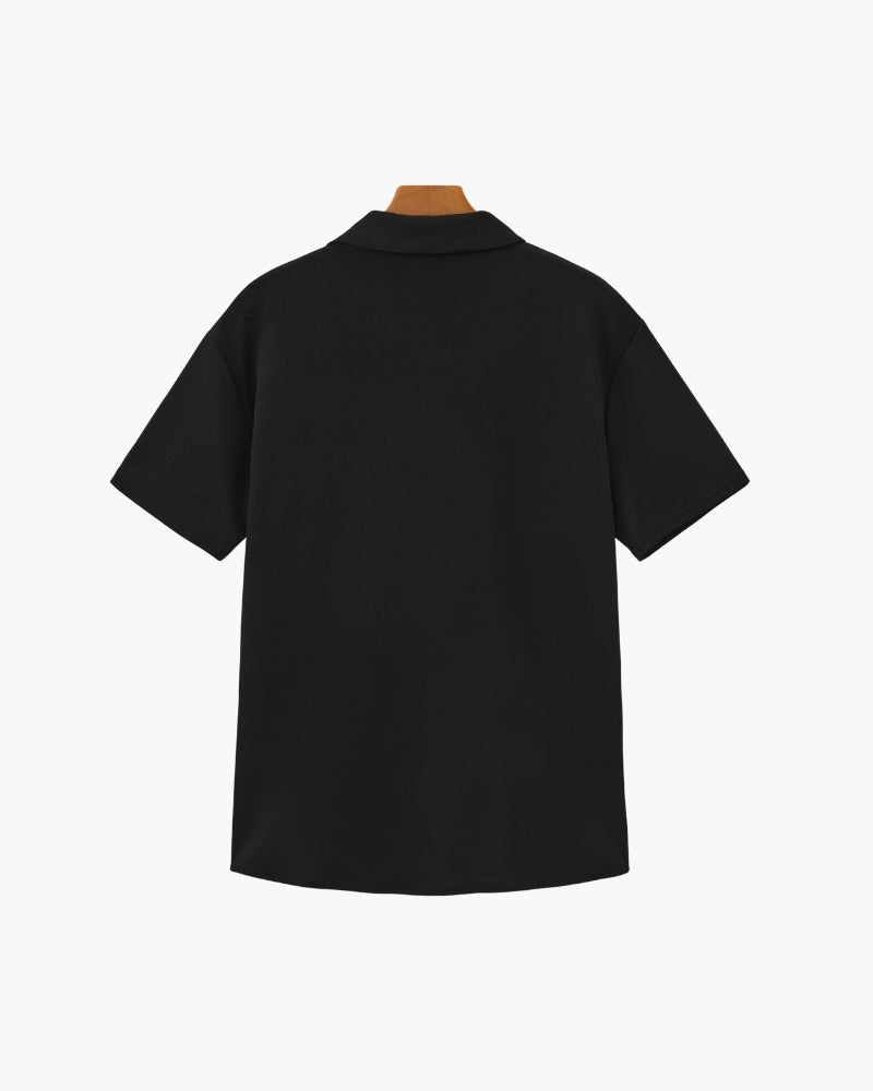 Back of a black short-sleeve polo with notch collar on a hanger